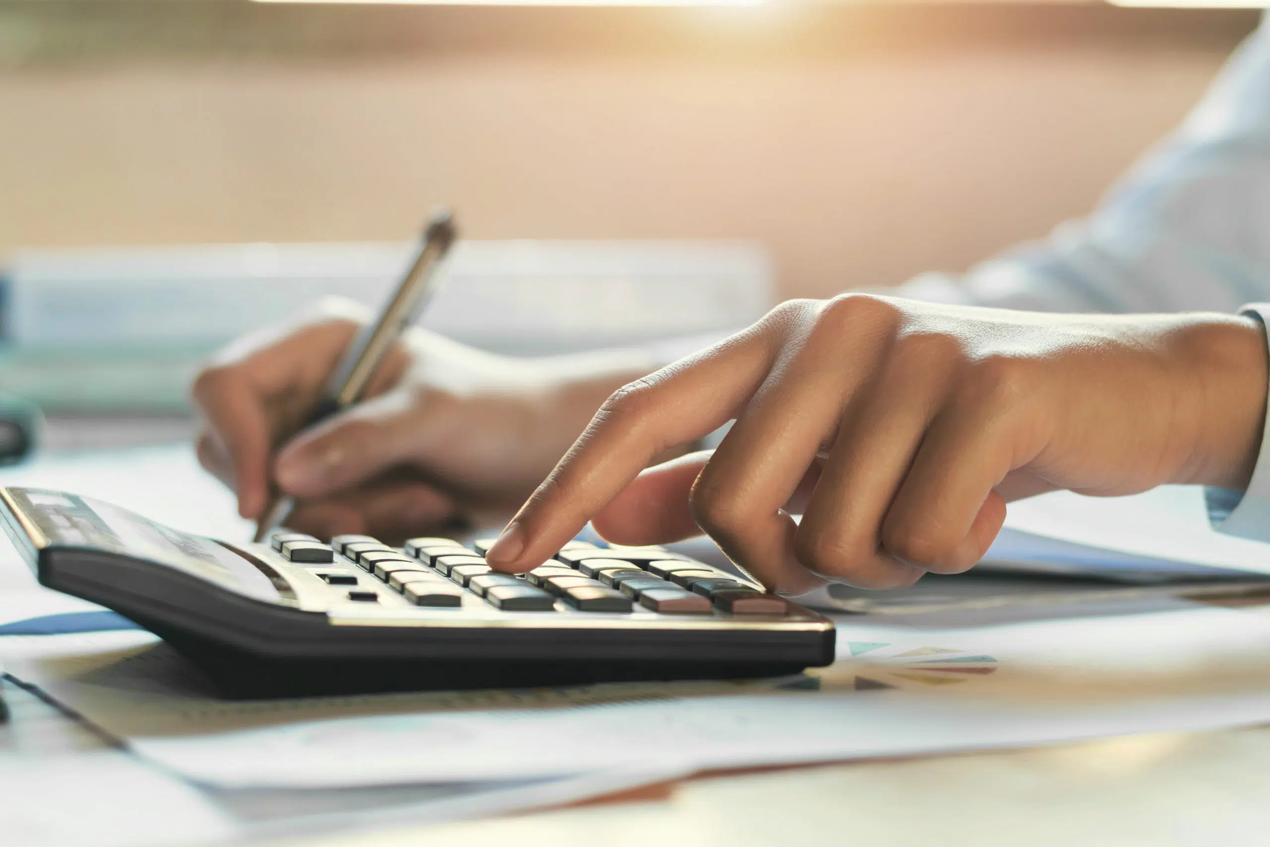 businessman working on desk office with using a calculator , finance accounting concept