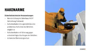 Vortrag Abrollkipper Gelber Hakenarm greift in eine Metallstruktur, Nahaufnahme von unten vor blauem Himmel